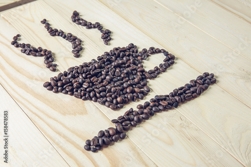 coffee beans is cup icon on wooden background and effect filter.