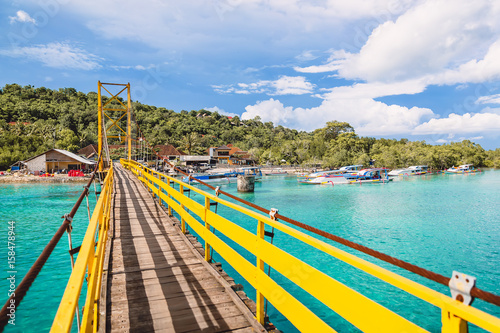 Tropical island in Indonesia, ocean and yellow bridge.
