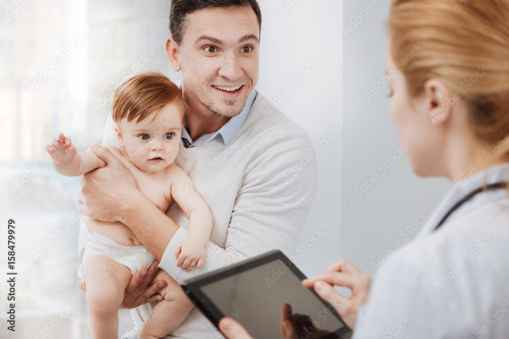 Delighted skillful doctor telling results of medical tests Delighted skillful doctor telling results of medical tests