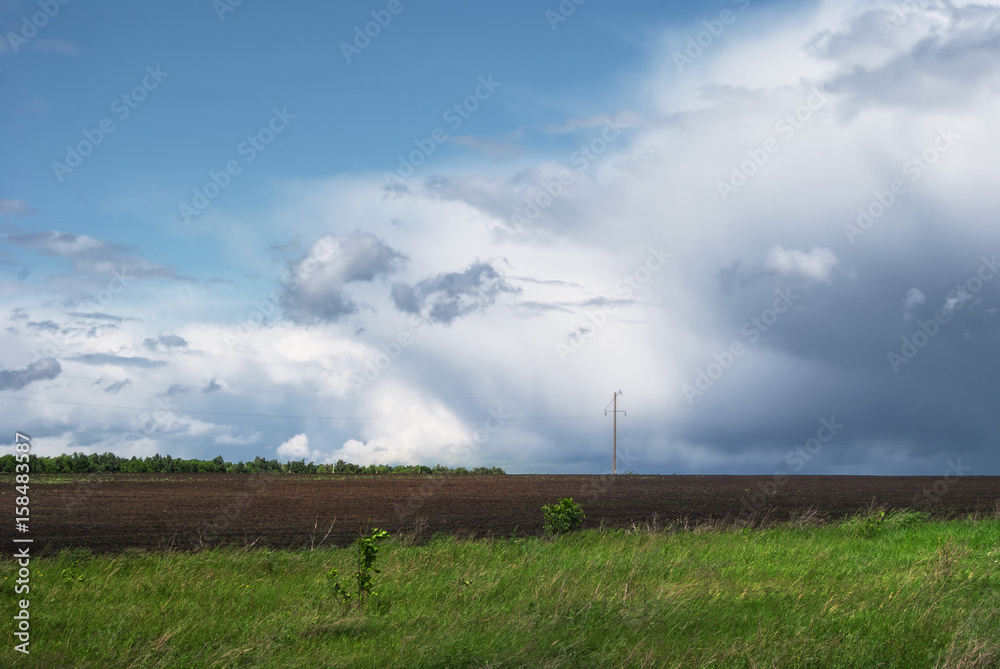 Beautiful rain clouds over the green fields of Russia