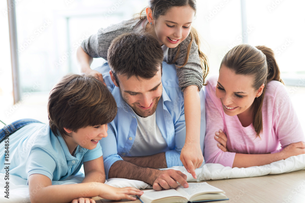 Happy family reading book together

