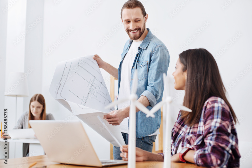 Obraz premium Lively motivated engineers chatting about details of their eco project