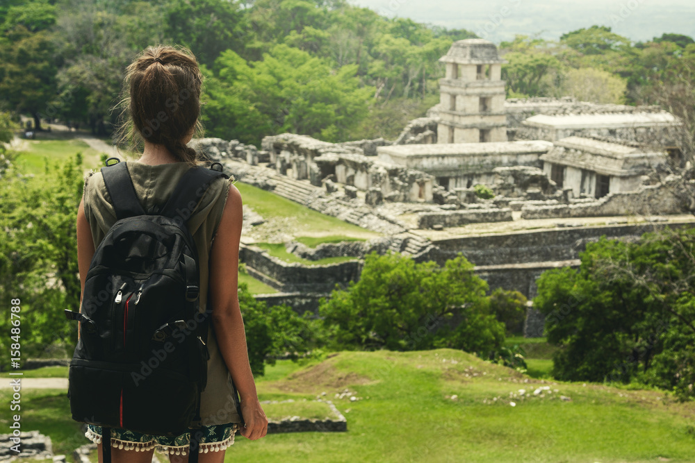 Woman with backpack beside ancient Mayan ruins - obrazy, fototapety, plakaty 