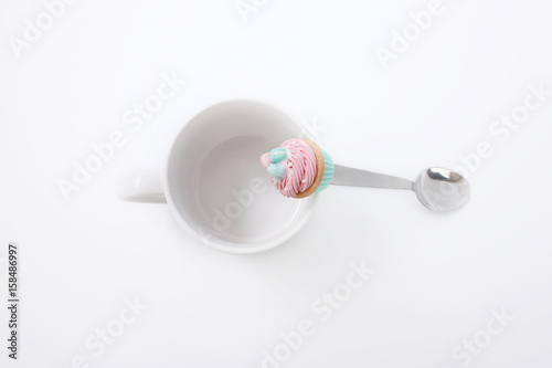 White cup with a spoon and cookies on a white background