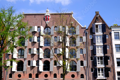 Photos front of large dutch canalside house in amsterdam with shutters