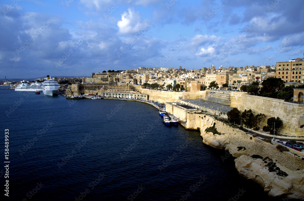 Cruise ship and traditional stone made buildings in city Valletta,Malta with coastline and blue sky in background