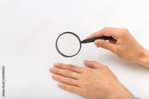 Female hands on white background with magnifier