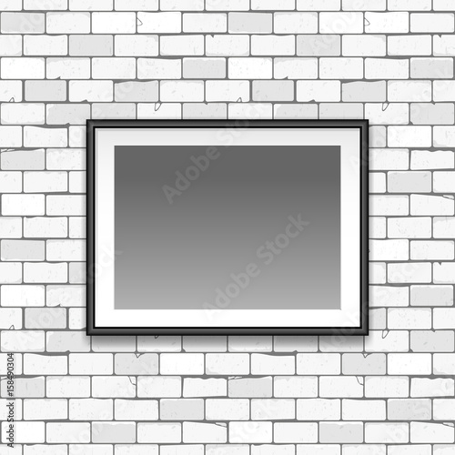 Gallery interior with empty black frame on gray old brick wall with cracks. Can be used as mock up. blank canvas in the frame