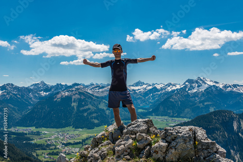 Powerful male hiker on mountain summit