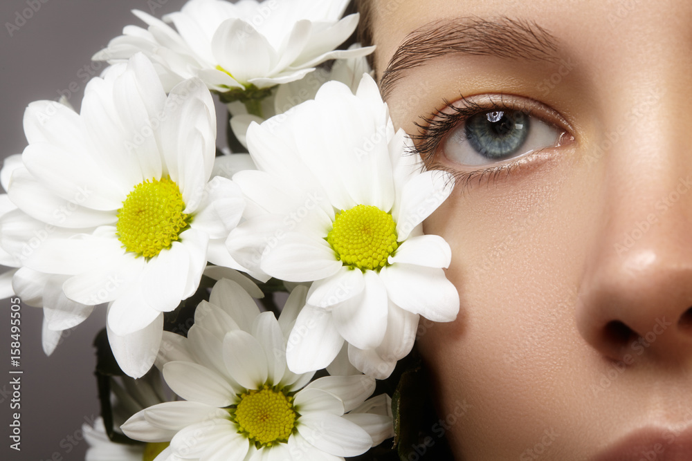 Beautiful blue female eye with white spring flower. Clean skin, fashion naturel make-up. Good vision, healthcare