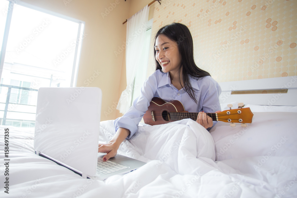 Happy young asian woman playing ukulele live at social with attractive smiling, 20s year old. Happy young asian woman playing ukulele live at social with attractive smiling, 20s year old.