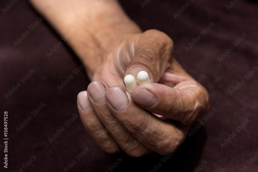Two white pills in old men's hands . Painful old age. Health care of older people. Two white pills in old men's hands . Painful old age. Health care of older people.