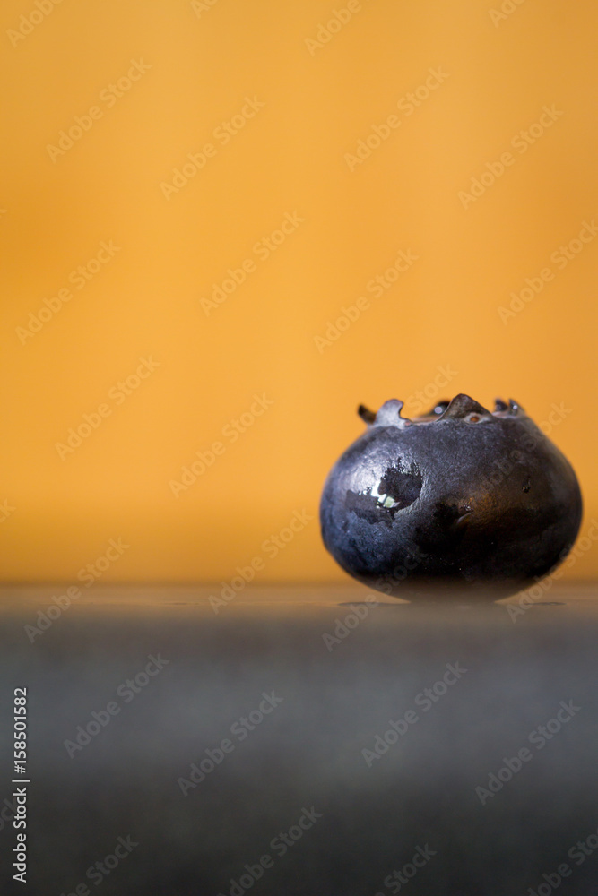 Fototapeta premium Ripe Blueberry close up with Orange background-Macro