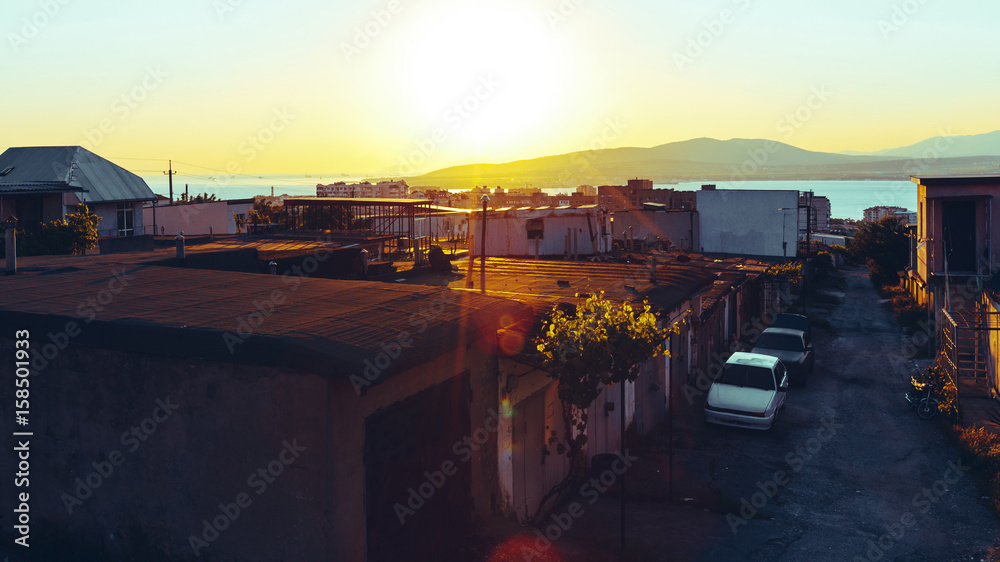 Favelas, slum, garages in the background of a picturesque landscape and sunset