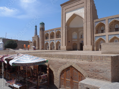 shops of souvenir in front of  an old traditional madrasah where students went to learn. Front view of Kutlug Murad Inaq Madrasah in Khiva, UzbekistanMadrasah in Khiva, Uzbekistan photo