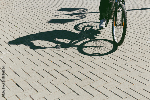 Shadow of man driving bicycle and lantern in the park