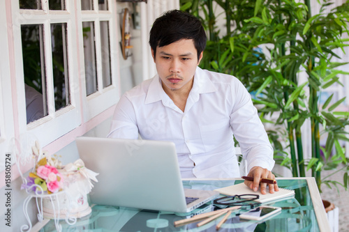 Middle aged businessman working from home using laptop at kitchen table