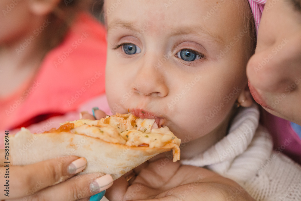 Mom and children eating pizza at a cafe