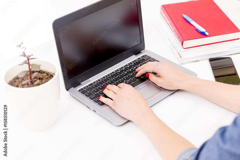 Womans hands on notebook working in clean and bright office, at home, freelance Womans hands on notebook working in clean and bright office, at home, freelance