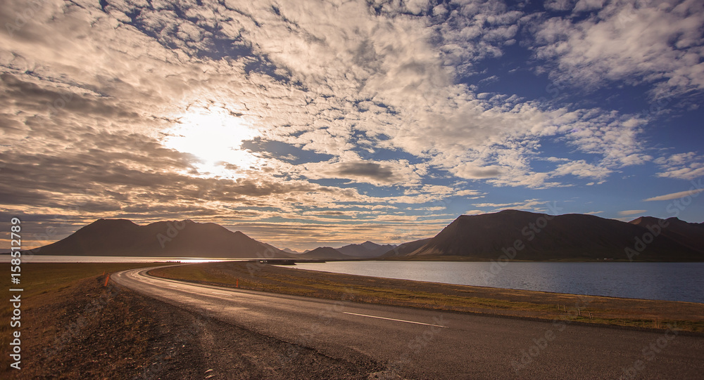 beautiful empty road bridge leading to mountain with colorful cloudscape in Iceland beautiful empty road bridge leading to mountain with colorful cloudscape in Iceland