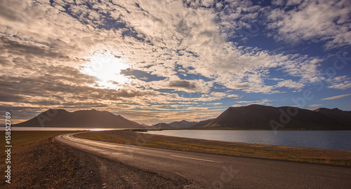 beautiful empty road bridge leading to mountain with colorful cloudscape in Iceland © Victorflowerfly