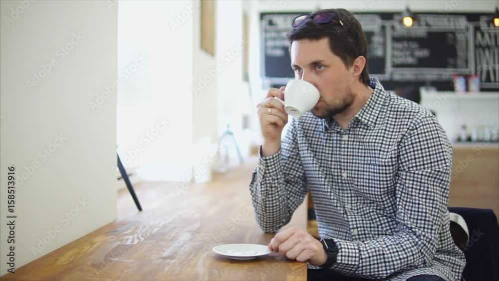 Man in casual shirt drinking coffee in cafe. Coffee break and leisure in the city Man in casual shirt drinking coffee in cafe. Coffee break and leisure in the city
