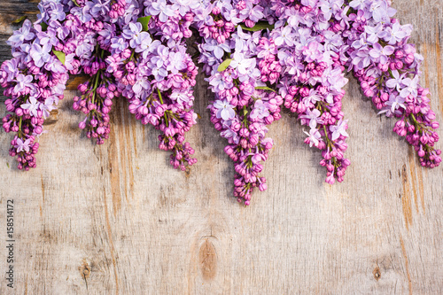 Bunches of lilac on old shabby wooden background