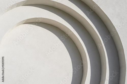 Abstract lines of arches in a white plastered wall. Abstract background with flowing lines. Architecture backdrop