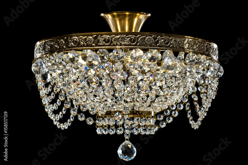 Large crystal chandelier isolated on black background.