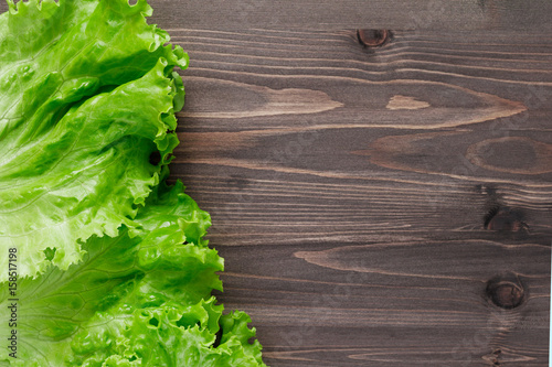 Top view of fresh lettuce leaves on wooden table. Copy space.