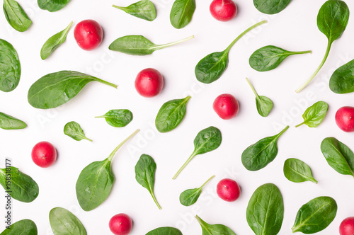 Pattern of spinach and vegetables isolated. Spinach leaves and radish on white background. Creative food concept. Ingredient for salad. Flat lay, top view
