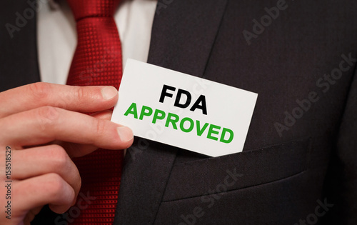 Businessman putting a card with text FDA Approved in the pocket photo