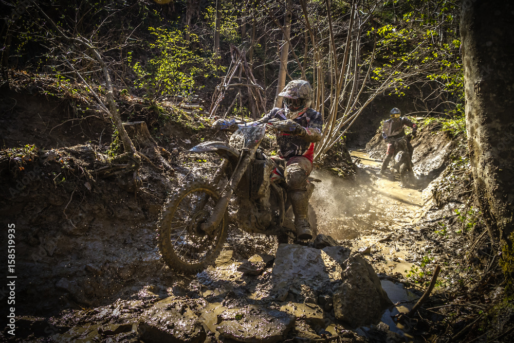 Motocross rider passes through the mud on the hardenduro race