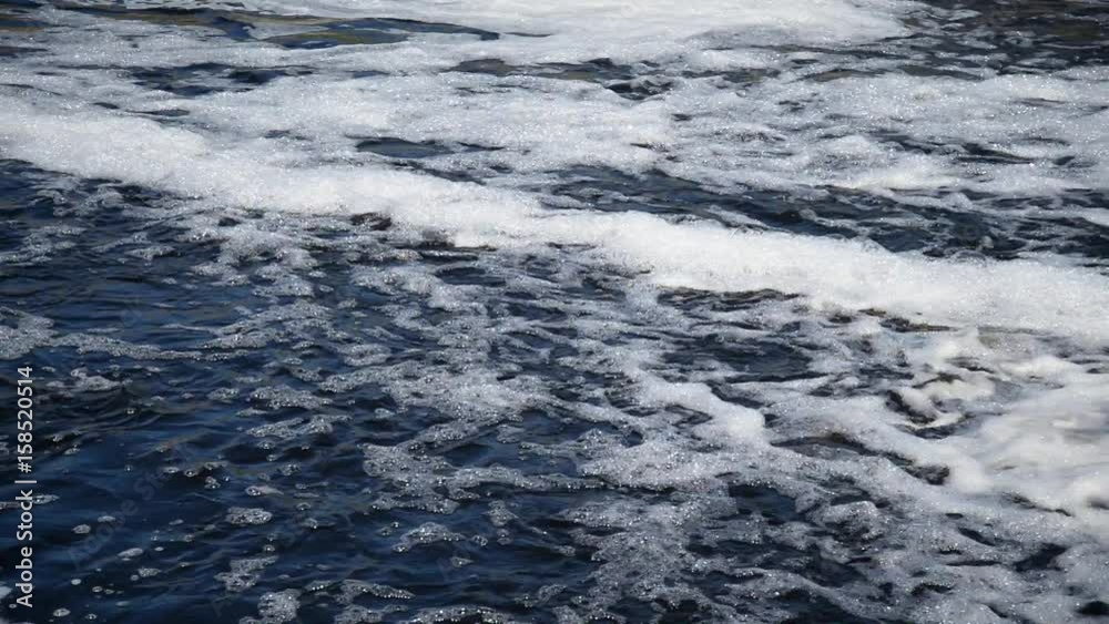 Flowing water with foam on the river at sunny summer day. Flowing water with foam on the river at sunny summer day.