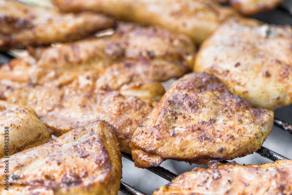 Grilling chicken breast on barbecue grill 