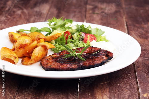 Grilled steaks, baked potatoes and salad