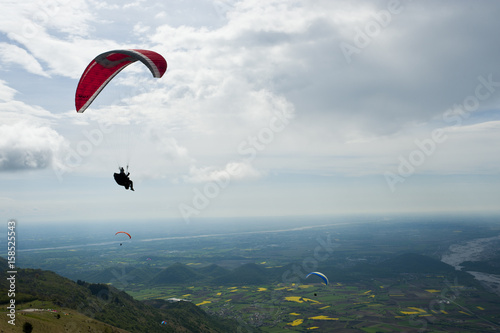 People fling paragliding over the Friulian plain.