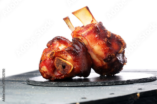Canvas Print Smoked ham hock with herbs and spices on wooden plate.