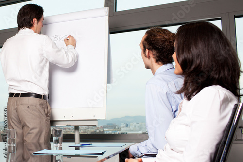 Businessmann schreibt auf Tafel im Workshop