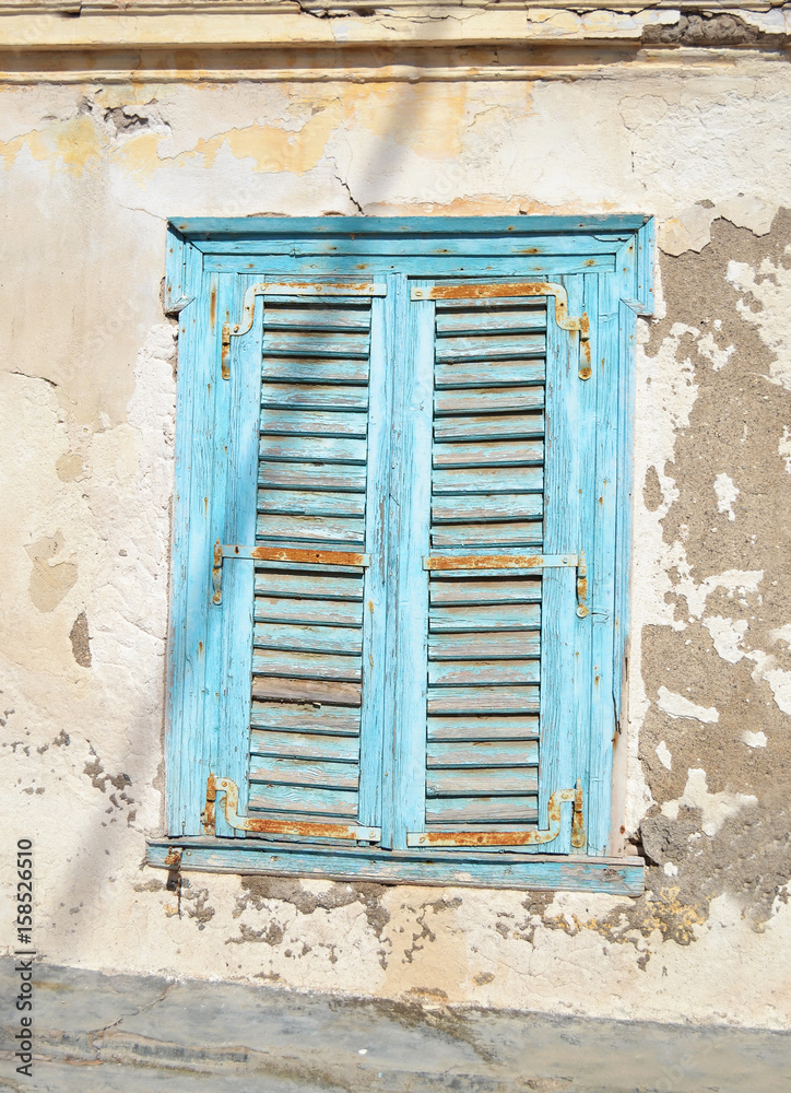 old blue wooden window with rust - abandoned house Hydra island Greece