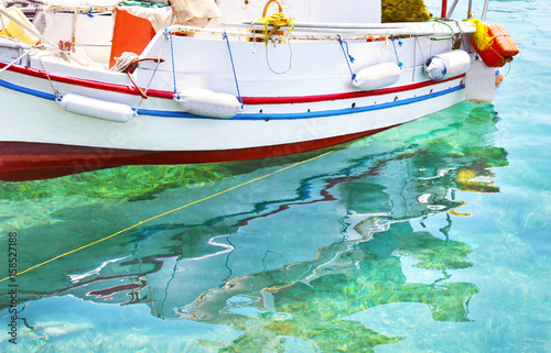 fishing boat reflected on sea Aegina island Greece © photo_stella