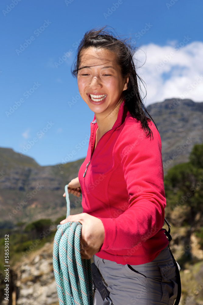 smiling asian female climber with rope on mountain smiling asian female climber with rope on mountain
