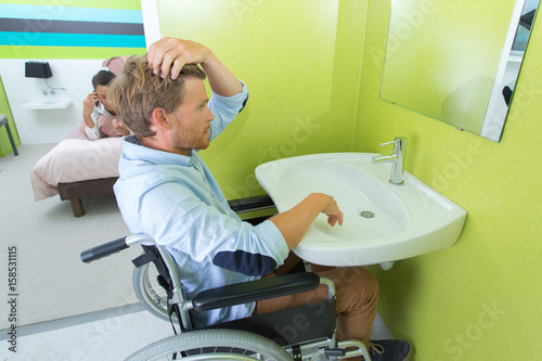 Canvastavla Disabled man styling hair at sink
