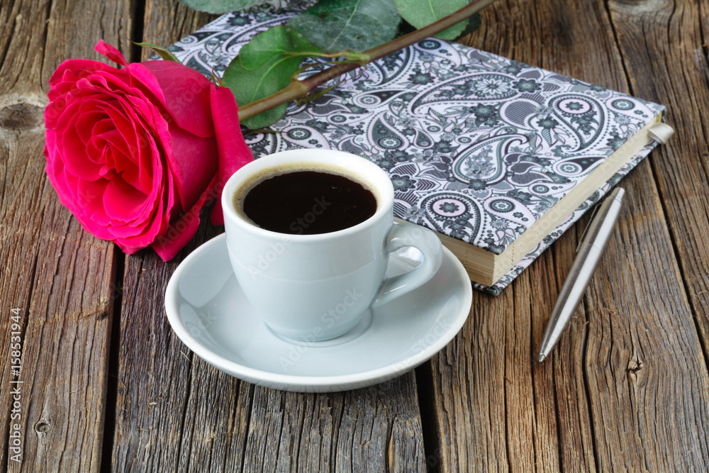 book with beautiful roses and cup of coffee on wooden table close up book with beautiful roses and cup of coffee on wooden table close up