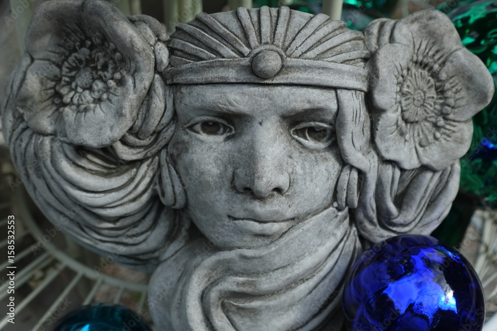 Steinfigur mit blauer Kugel