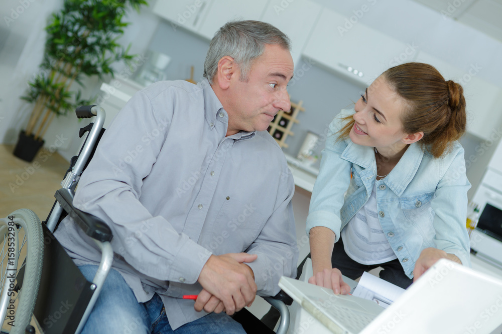 Young lady talking to man in wheelchair Young lady talking to man in wheelchair