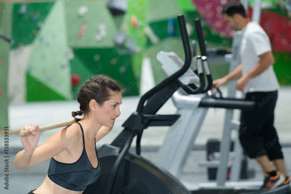Fototapeta premium Lady doing fitness routine using wooden stick