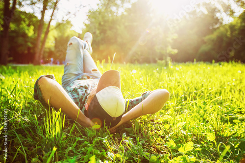Carefree hipster is having leisure at bright sunny park background. © Mayatnikstudio