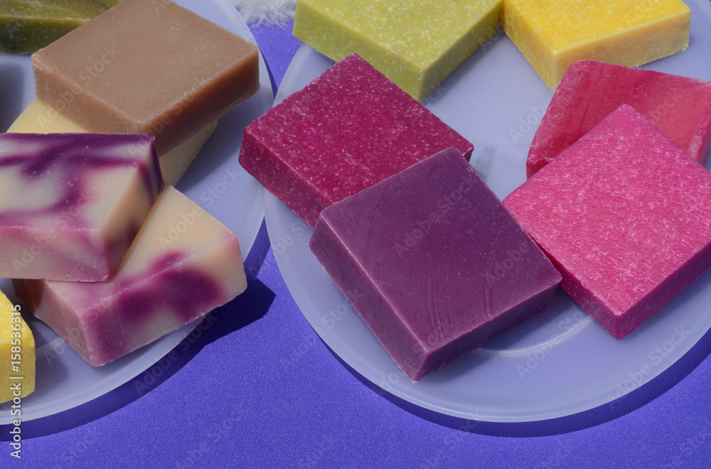 Colorful handmade beeswax soap squares on plates Colorful handmade beeswax soap squares on plates