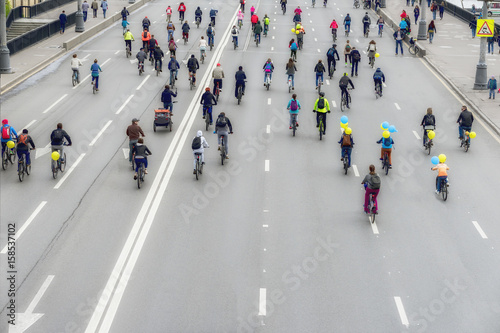 Large group of bicyclists on street, city marathon, Back to us, unrecognizable. Sport, healthy lifestyle concept. For backdrop, place for text